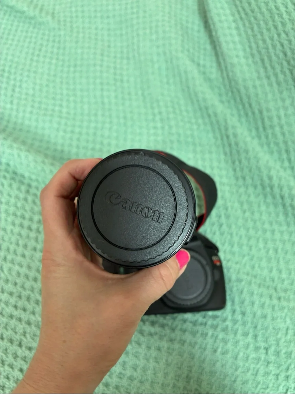 Canon DSLR Camera Body in Black with Red Strap Accents and kit lens.